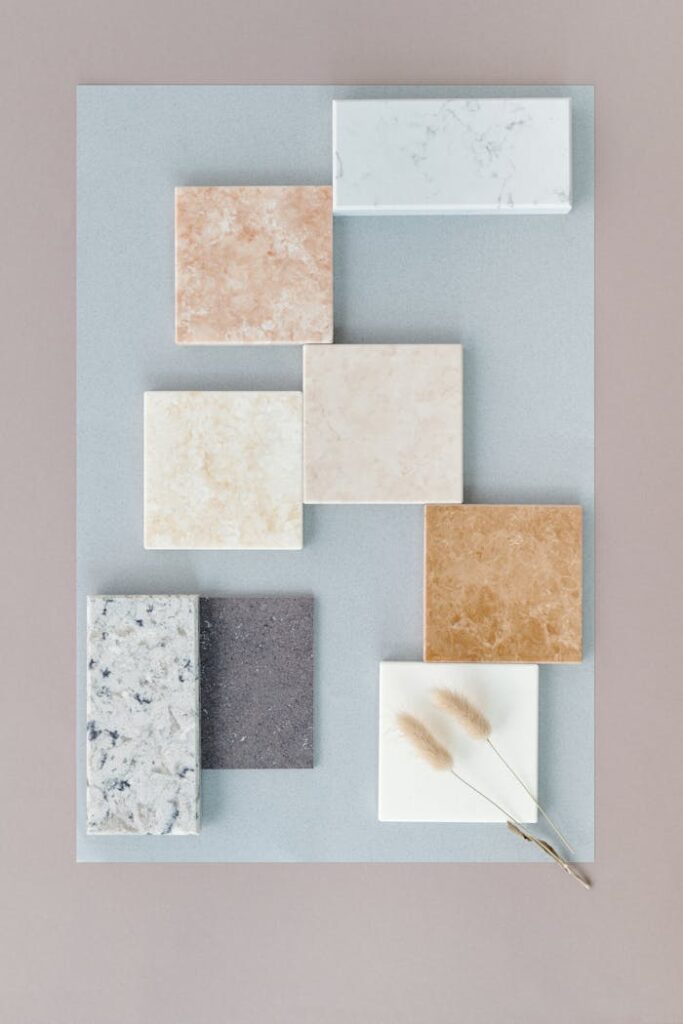 Flat lay of various marble tiles arranged on a soft neutral backdrop for design inspiration.